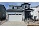 Charming two-story home featuring a two-car garage, a cozy front porch, and stylish gray siding at 2221 Flower Blossom Ave, Brighton, CO 80601