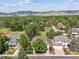 Aerial view featuring well-kept homes, tennis courts, and a backdrop of rolling hills and mature trees at 4059 Nevis St, Boulder, CO 80301