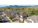 Breathtaking aerial view of a residential neighborhood with lush green trees, scenic mountains, and a well-maintained tennis court at 4059 Nevis St, Boulder, CO 80301