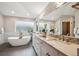 Luxurious bathroom boasts a soaking tub, double vanity with marble countertops, and modern fixtures at 4059 Nevis St, Boulder, CO 80301