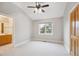 Clean bedroom offers neutral colors, a ceiling fan, and view into an attached bathroom at 4059 Nevis St, Boulder, CO 80301