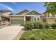 Charming single-story home featuring a stone facade, green lawn, and an attached two-car garage at 7201 W Asbury Pl, Lakewood, CO 80227