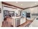 Modern kitchen with stainless steel appliances, island sink, and hardwood floors open to the dining and living area at 7201 W Asbury Pl, Lakewood, CO 80227
