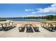 Lakeside park featuring picnic tables and sandy beach area near the calm lake waters and lush vegetation at 7201 W Asbury Pl, Lakewood, CO 80227