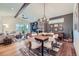 Inviting living room with a stone fireplace, wood floors, and a cozy dining area with modern chandelier at 7201 W Asbury Pl, Lakewood, CO 80227