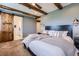 Comfortable main bedroom with wood beam ceiling, barn door and modern decor at 7201 W Asbury Pl, Lakewood, CO 80227