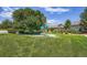 Community playground on lush lawn features play structure and mature trees for fun outdoor activities at 7201 W Asbury Pl, Lakewood, CO 80227