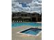 Community pool and spa with lounge chairs and building in background at 17346 Nature Walk Trl # 201, Parker, CO 80134