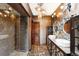 Modern bathroom with glass shower, double sinks, unique mirrors and vanity, and modern lighting fixtures at 2150 Curtis St, Denver, CO 80205