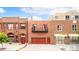 Brick building featuring a garage door, balconies, and street-level access at 2150 Curtis St, Denver, CO 80205