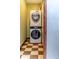 Laundry room featuring a stacked washer and dryer, checkered floor, and neutral colored walls at 2150 Curtis St, Denver, CO 80205