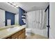 Bathroom featuring blue walls, modern fixtures, and bathtub with marble-patterned shower curtain at 14300 E Marina Dr # 109, Aurora, CO 80014