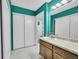 Bathroom with white tile floor, updated vanity, mirror, and dual closets at 14300 E Marina Dr # 109, Aurora, CO 80014
