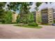 View of an apartment building exterior boasting balconies and surrounded by mature trees, set within a well-maintained landscape at 14300 E Marina Dr # 109, Aurora, CO 80014