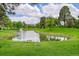 Picturesque pond with a fountain, surrounded by lush greenery and mature trees on the golf course at 14300 E Marina Dr # 109, Aurora, CO 80014