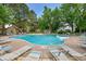Inviting swimming pool surrounded by lounge chairs and mature trees, creating a perfect spot for relaxation and recreation at 14300 E Marina Dr # 109, Aurora, CO 80014