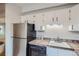 Bright kitchen featuring white cabinetry, stainless steel appliances, and tile countertops at 555 E 10Th Ave # 214, Denver, CO 80203