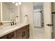 Simple bathroom with wood vanity, shower/tub combo, and patterned floor at 5268 Talavero Pl, Parker, CO 80134