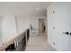 Upstairs hallway with light carpet, wood railing, and access to bedrooms and bathroom at 5268 Talavero Pl, Parker, CO 80134