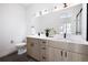 Modern bathroom features double vanity with quartz countertop, wood cabinets, black hardware, and sleek fixtures at 2920 W Parkside Pl, Denver, CO 80221