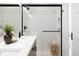 Modern shower with sleek glass enclosure, rain shower head, and white tile surround next to vanity at 2920 W Parkside Pl, Denver, CO 80221