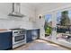 Bright kitchen with stainless steel appliances and herringbone tile backsplash with backyard access through double doors at 1002 Detroit St, Denver, CO 80206