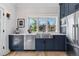 Modern kitchen boasts navy cabinets, quartz countertops, and stainless steel appliances, creating a chef's haven at 1002 Detroit St, Denver, CO 80206
