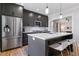 A stylish kitchen showcasing stainless steel appliances, gray cabinets, and a kitchen island with seating at 1002 Detroit St, Denver, CO 80206