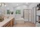 Bright bathroom with vanity, soaking tub, and glass enclosed shower with tile surround at 1935 Poncha Ct, Larkspur, CO 80118