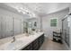 Bathroom with dual vanity sinks, tile flooring, updated lighting, and glass-enclosed shower at 1935 Poncha Ct, Larkspur, CO 80118