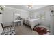 Clean bedroom with a white vanity, light-colored furniture, and natural light from a window at 1935 Poncha Ct, Larkspur, CO 80118