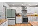 Modern kitchen featuring white cabinets, stainless steel appliances, and ample counter space at 1935 Poncha Ct, Larkspur, CO 80118