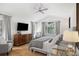 Bright main bedroom with vaulted ceiling, TV, ceiling fan, and picture window with wooded view at 1935 Poncha Ct, Larkspur, CO 80118