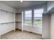 A walk-in closet with white shelving and neutral carpet is well lit by three windows at 23708 E 42Nd Ave, Aurora, CO 80019