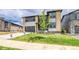 Modern two-story home with well-maintained lawn, a spacious driveway, and lush, young tree at 23708 E 42Nd Ave, Aurora, CO 80019