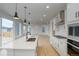 Spacious kitchen with island, pendant lighting, modern appliances, and hardwood floors at 23708 E 42Nd Ave, Aurora, CO 80019