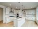 Bright, open kitchen with stainless steel appliances, a center island, and sleek white cabinetry at 23708 E 42Nd Ave, Aurora, CO 80019