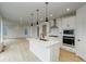 Open-concept kitchen boasts stainless steel appliances, island with seating, and hardwood floors at 23708 E 42Nd Ave, Aurora, CO 80019