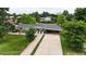 Aerial view of a single-story home with attached carport, driveway, and a well-manicured lawn at 8455 W Belmar Ave, Lakewood, CO 80226