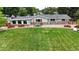 Lush backyard featuring vibrant green grass, mature trees, and cozy patio seating at 8455 W Belmar Ave, Lakewood, CO 80226