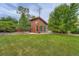 Backyard studio with stylish lighting and a wood finish, surrounded by a landscaped lawn at 8455 W Belmar Ave, Lakewood, CO 80226