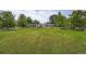 Spacious backyard offers a well-manicured lawn, mature trees, and a view of the home's exterior at 8455 W Belmar Ave, Lakewood, CO 80226