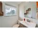 Bright bathroom features a modern vanity, decorative shelves, and a window offering natural light at 8455 W Belmar Ave, Lakewood, CO 80226