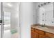 Bright bathroom features a wood vanity, large mirror, and tub/shower combo at 7411 S Crescent Ct, Littleton, CO 80120