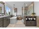 Bathroom with a soaking tub, walk-in shower, vanity sink, and towel storage at 7411 S Crescent Ct, Littleton, CO 80120