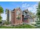 Charming exterior elevation with brick accents, large windows and a well-manicured lawn at 7411 S Crescent Ct, Littleton, CO 80120