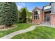 Beautiful front yard with lush green lawn, a stone walkway and mature landscaping at 7411 S Crescent Ct, Littleton, CO 80120