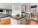 Gourmet kitchen featuring an island with seating and stainless steel appliances, seamlessly connecting to the living area at 7411 S Crescent Ct, Littleton, CO 80120