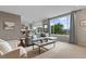 Bright living room with large windows offering beautiful views, a comfortable sofa, and a kitchen area at 7411 S Crescent Ct, Littleton, CO 80120