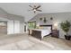 Spacious main bedroom featuring a vaulted ceiling, carpeted floor, a ceiling fan, and a view of the outdoors at 7411 S Crescent Ct, Littleton, CO 80120
